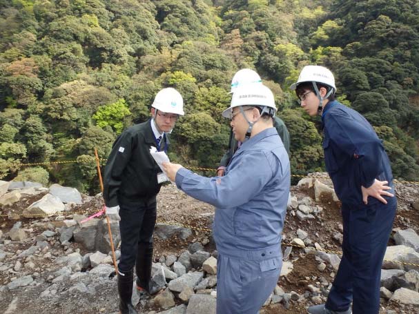 災害復旧現場で熊本復興事務所職員と打合せを行う研究室員