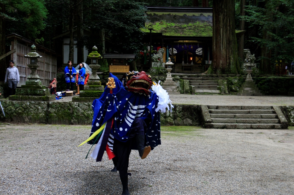 大木の麓にある稲荷社に御供をしている様子